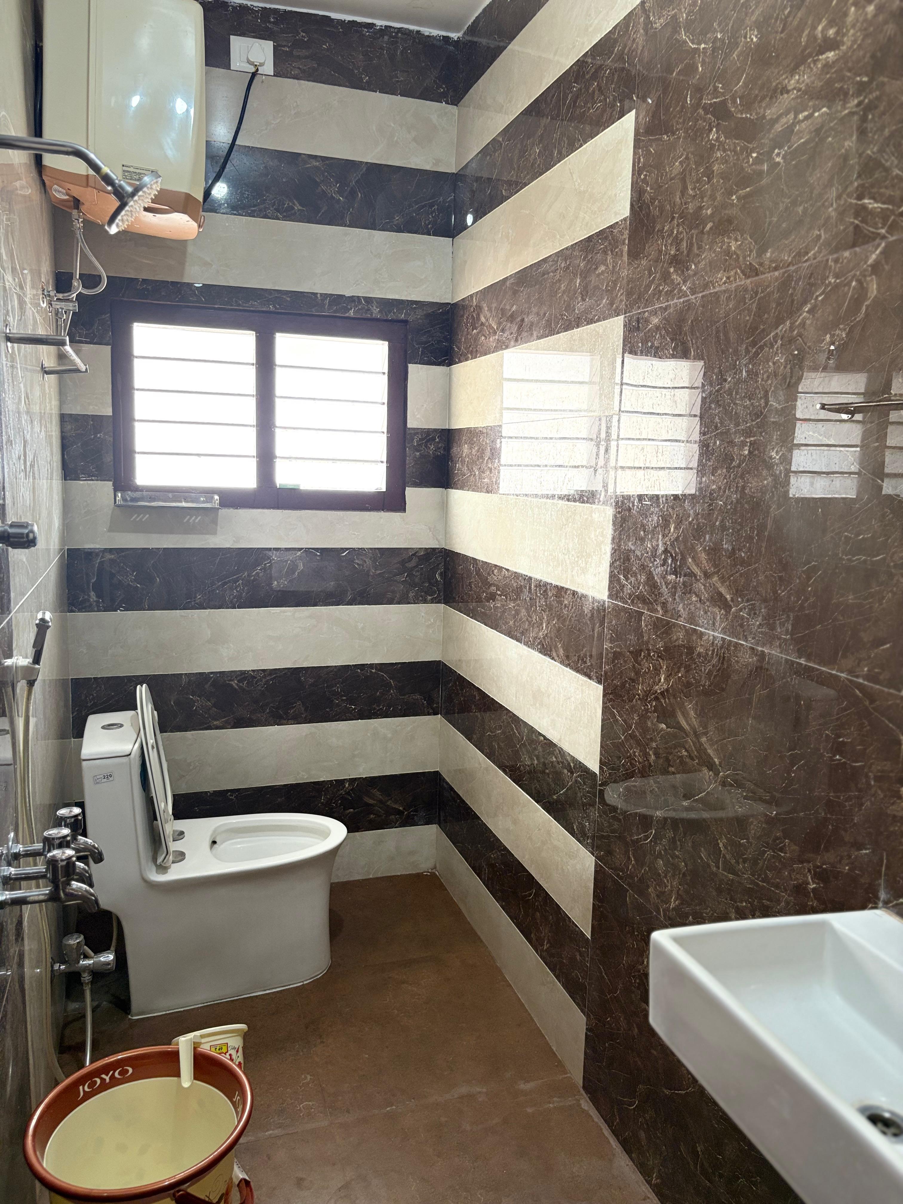 Modern marble-tiled bathroom with western toilet