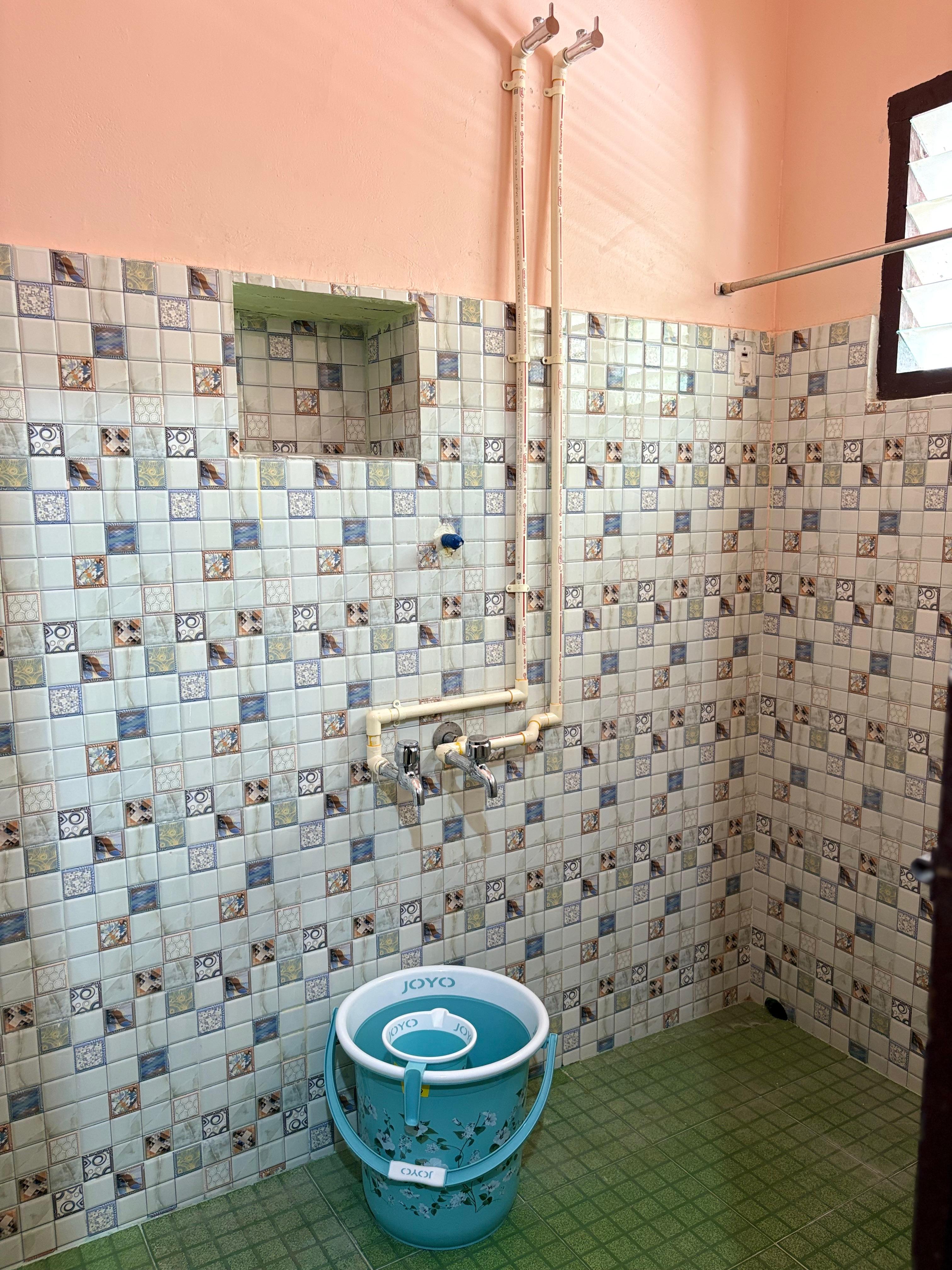Bathing area with tiled walls and dual taps