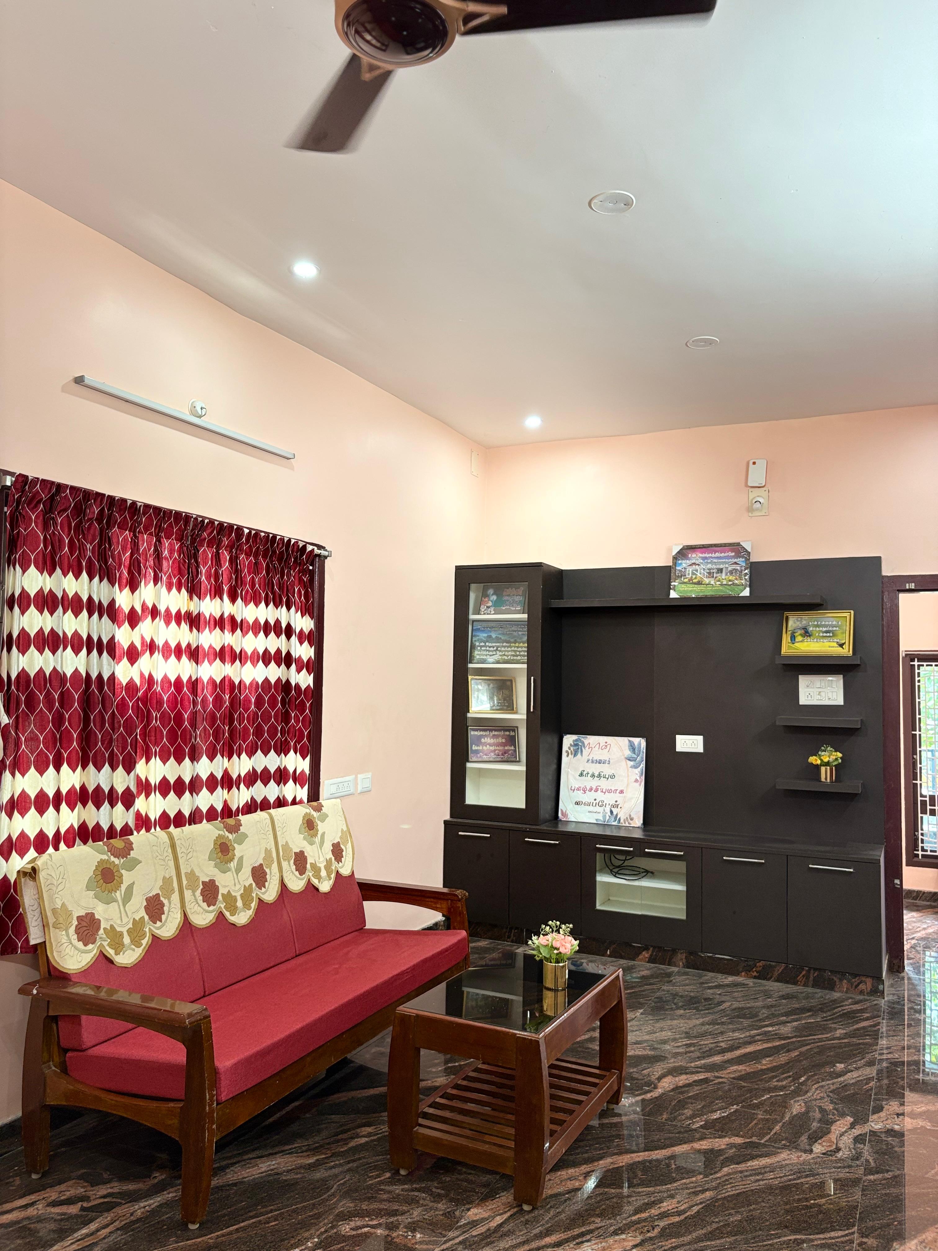 Living hall with red sofa and dark wood TV unit